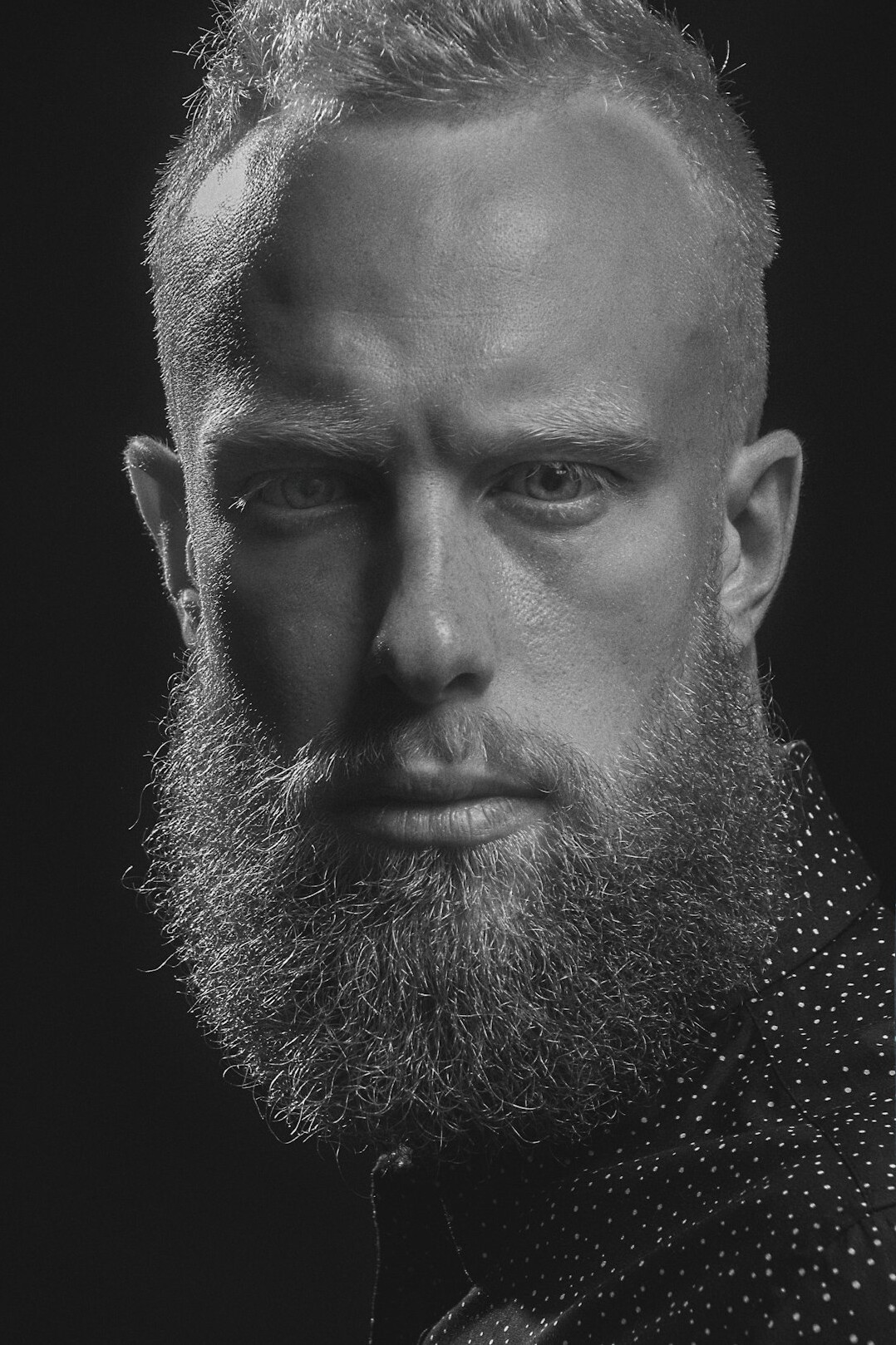 Studio headshot of a Danish male culture writer in his 30s with beard